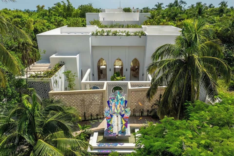 Contemporary white villa with arched doorways, rooftop garden, and colorful entrance art