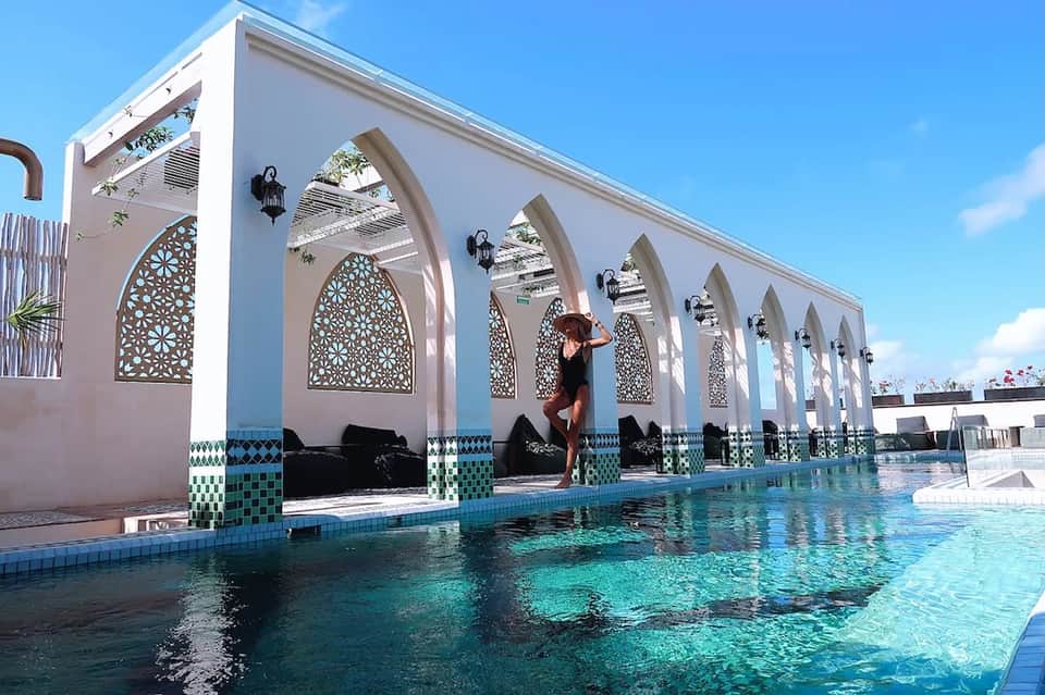 Resort pool with architectural white pergola structures and turquoise water