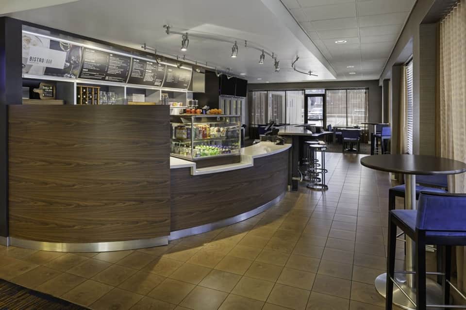 Modern cafe bistro interior with curved counter, menu boards, and seating area