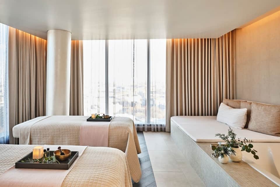 Luxury high-rise hotel room with city views, twin beds, and modern furnishings