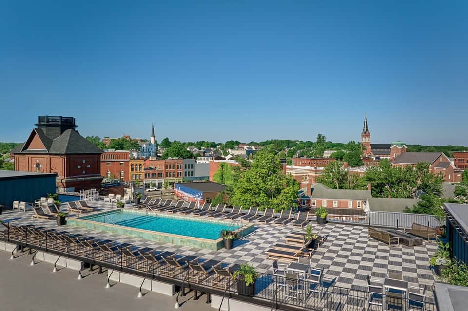 Rooftop pool overlooking historic downtown brick buildings and church steeples