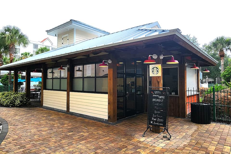 Brown wooden coffee shop exterior with white trim, windows, and Starbucks signage