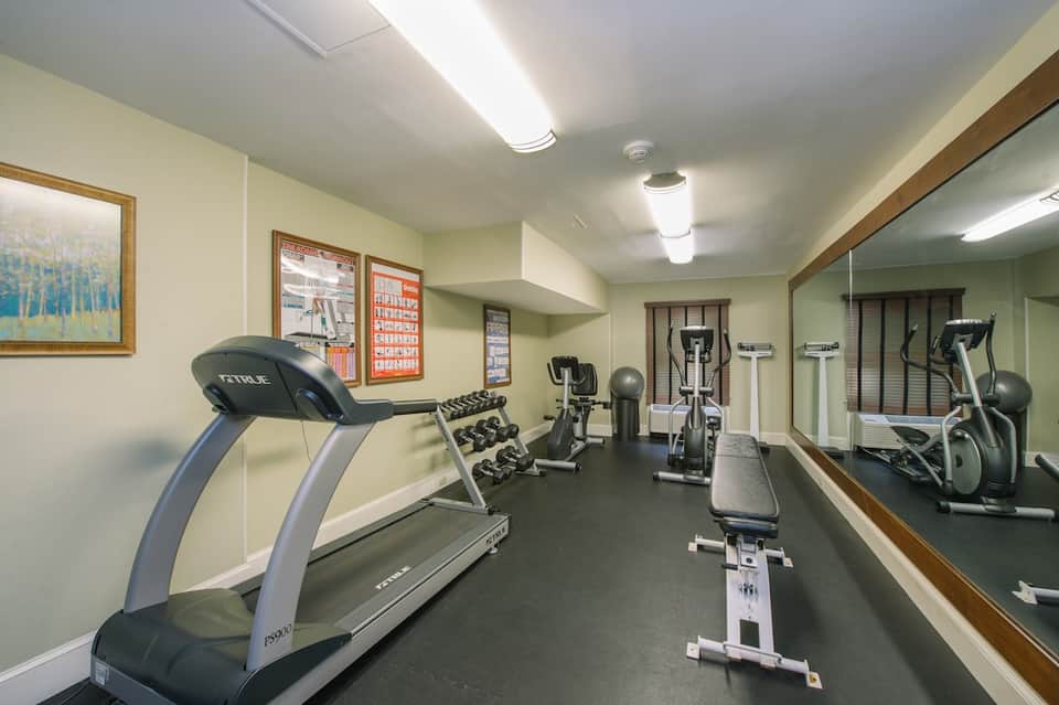 Fitness center with treadmills, free weights, exercise bikes, and mirrors