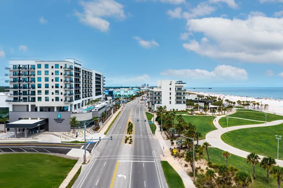 Modern beachfront resort development with turquoise pool and sandy beach access