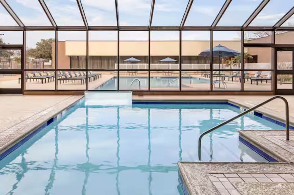Indoor pool under glass enclosure with viewing windows and spa area