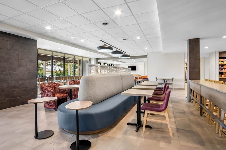Contemporary hotel lounge with blue and gray curved seating and modern ceiling fixtures
