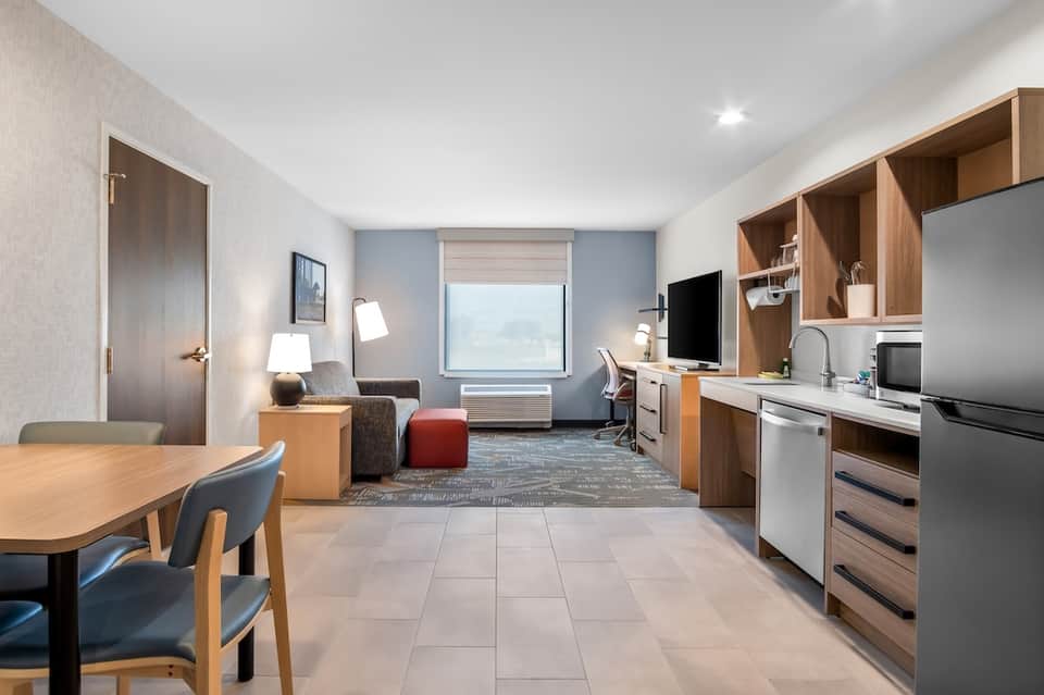Hotel suite with kitchenette, living area, work desk, and ocean view window