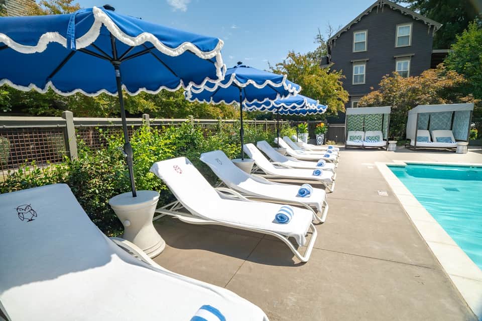 Poolside seating with blue and white striped umbrellas