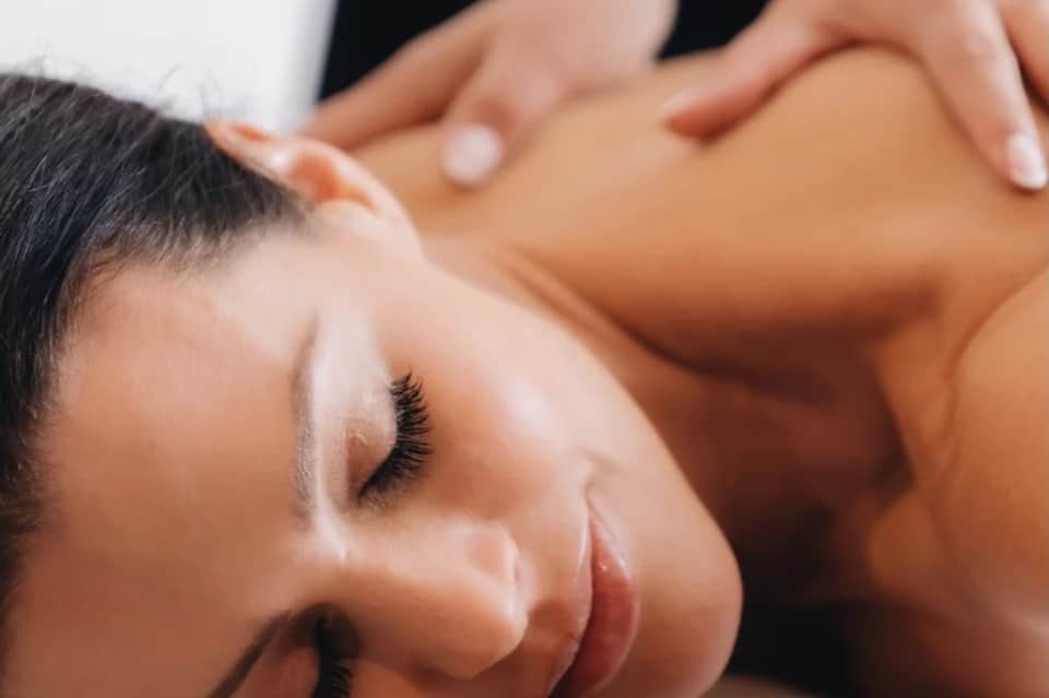 Close-up of facial massage therapy being performed on relaxed client at spa