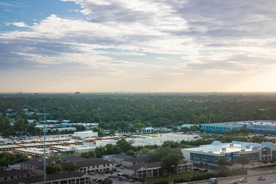 Cityscape aerial view showing suburban industrial and commercial areas with green landscape