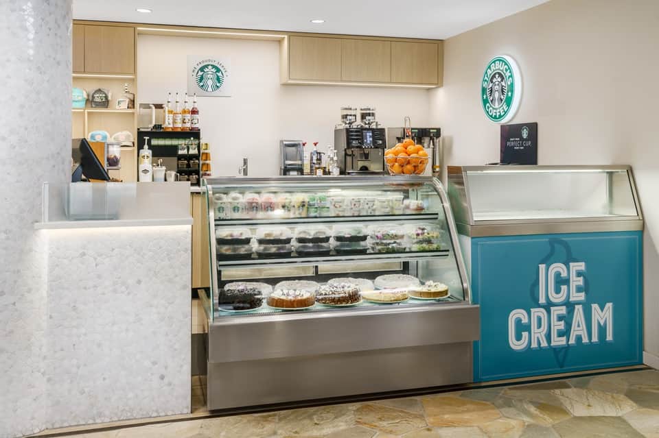 Hotel café interior with Starbucks counter, pastry display case, and ice cream sign