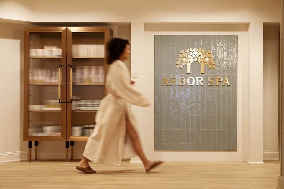 Arbor Spa entrance with wooden doors and decorative tree logo signage on wall
