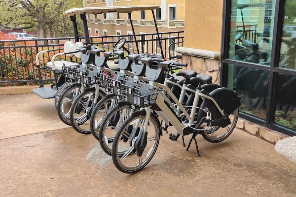 Hotel terrace with white bicycles lined up for guest use and scenic overlook