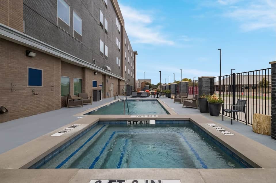 Two indoor lap pools with lane markings in modern brick facility with metal railings