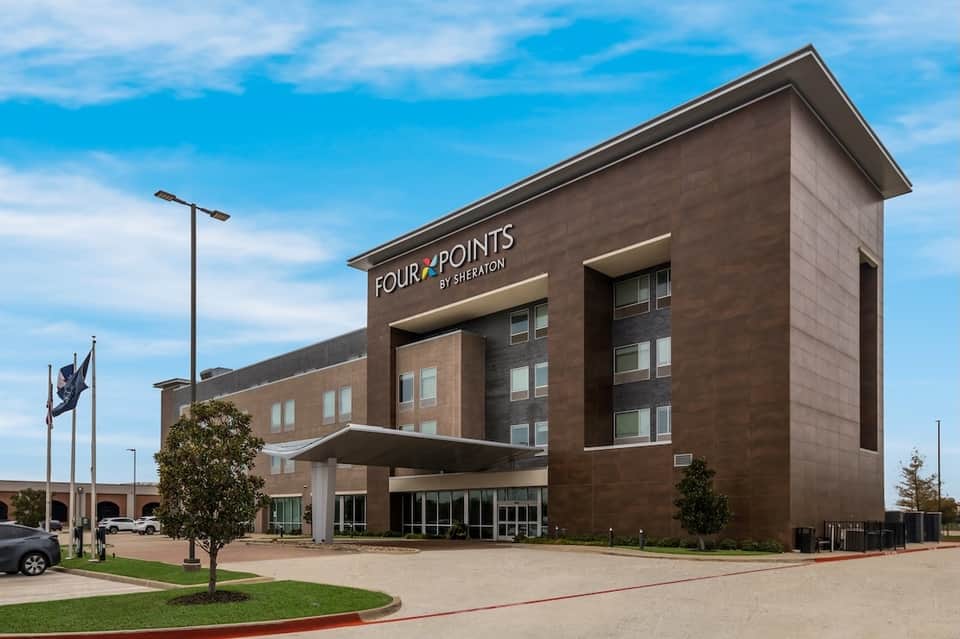 Four Points by Sheraton hotel exterior with modern brown brick architecture and manicured grounds