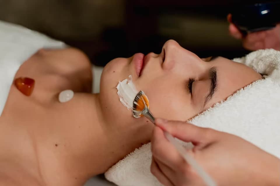 Close-up of facial treatment being applied to woman's face with professional spa products