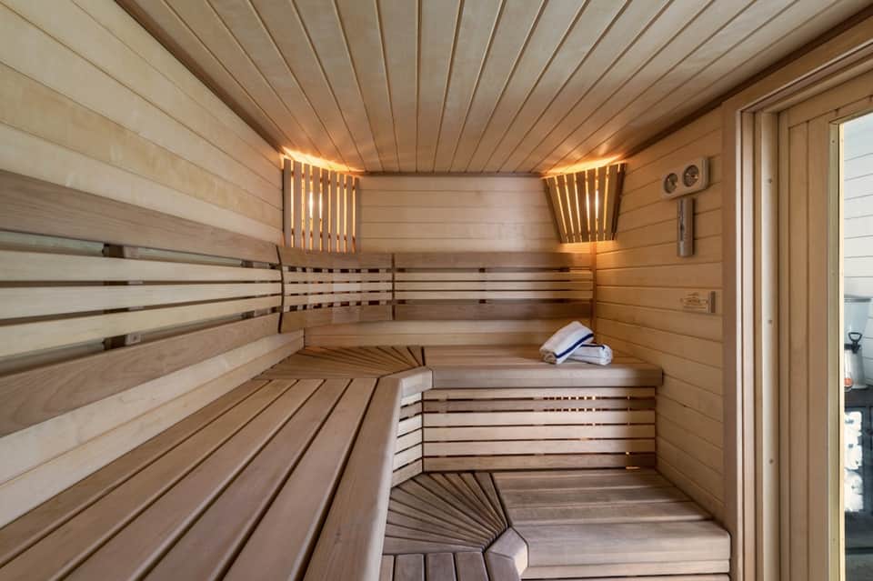 Wooden sauna interior with benches, warm lighting, and contemporary design elements