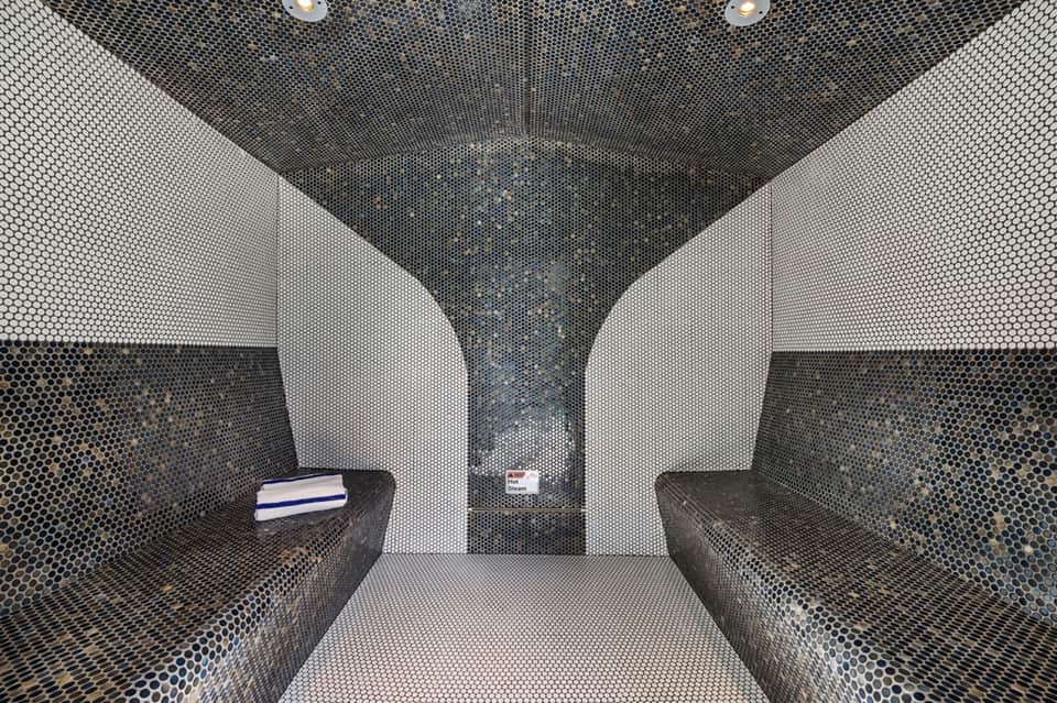 Modern spa steam room with perforated metal walls in white and black geometric pattern design