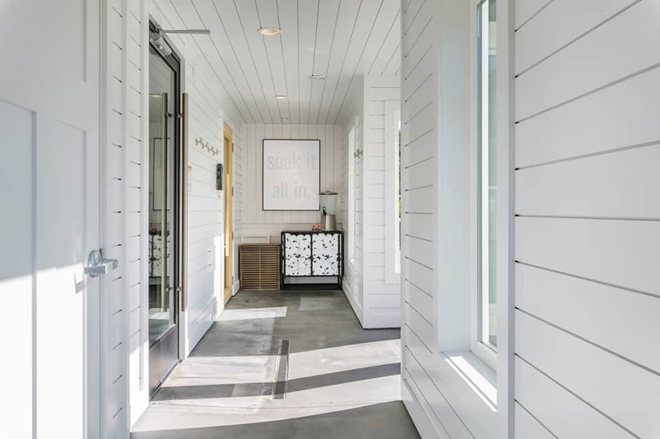 Modern white spa hallway with neutral tones and contemporary bathroom entrance