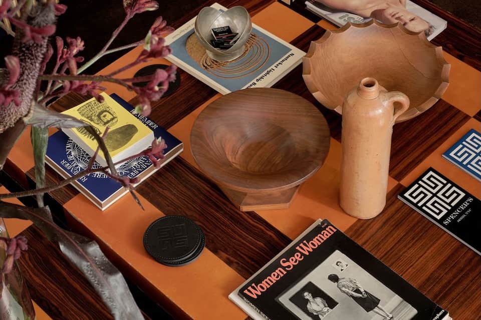 Luxury table display with wooden bowls, ceramic objects, dried flowers, and design magazines