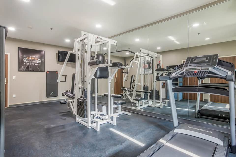 Modern fitness center with white gym equipment, treadmill, and motivational signage