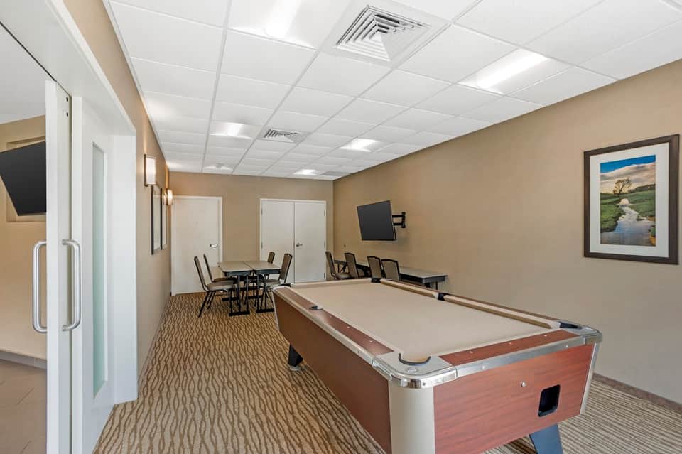 Game room with pool table, meeting area with table and chairs, and flat-screen TV