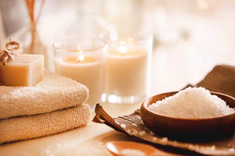 Spa amenities display with towels, bath salts, candles, and relaxation products