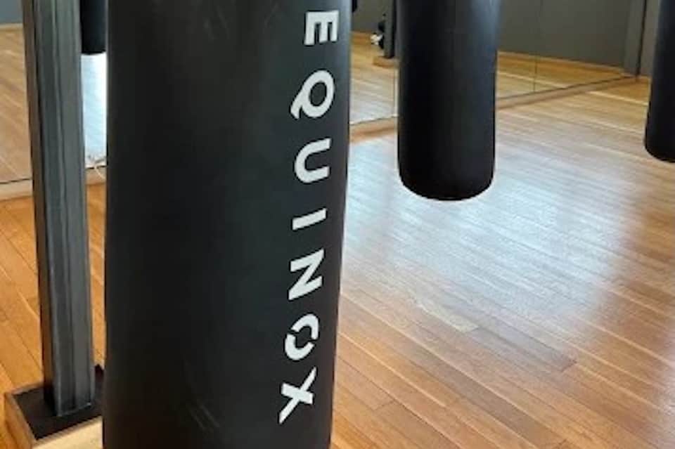Boxing gym with black heavy bags and wooden floor for fitness training