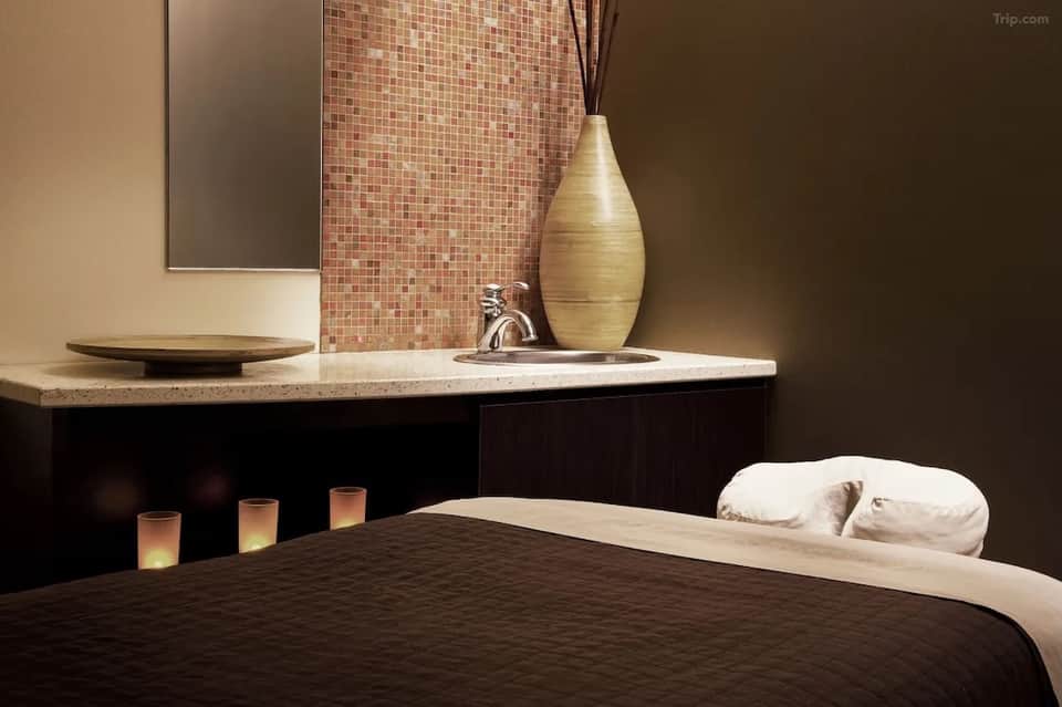 Spa massage room with ambient lighting, decorative vase, and relaxation ambiance