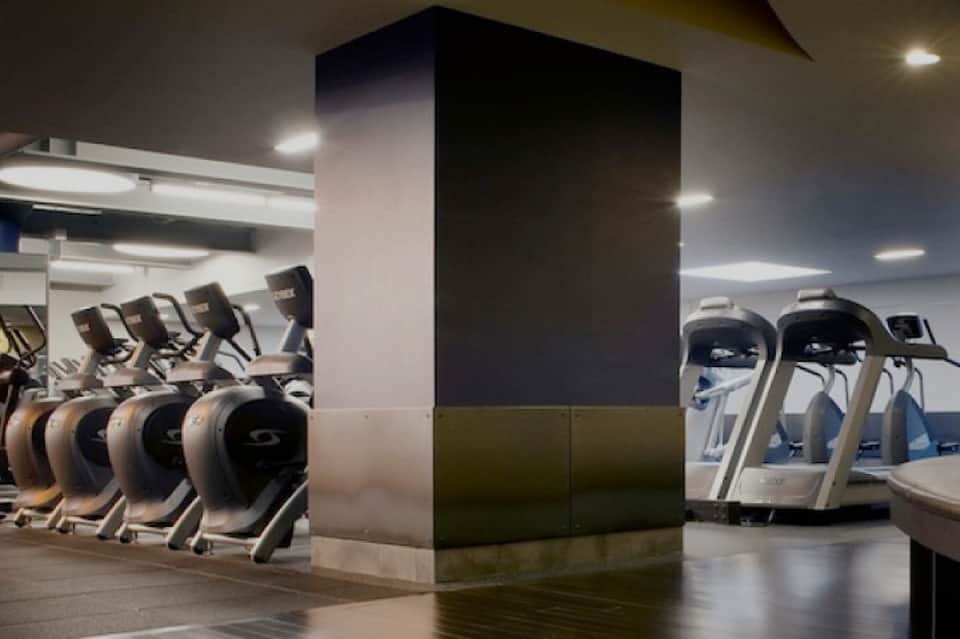 Modern fitness center with exercise equipment, ellipticals, treadmills, and contemporary design elements