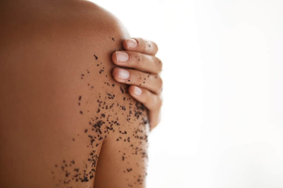 Close-up of person's torso with exfoliating body scrub treatment on skin