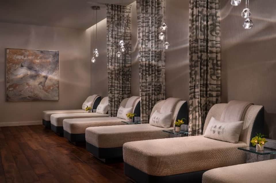 Luxury spa relaxation room with six massage beds and hanging crystal pendant lights
