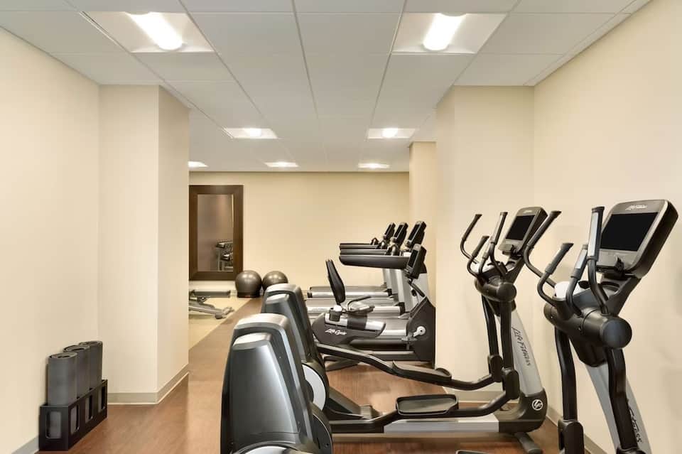 Fitness center with exercise machines, treadmills, and beige walls