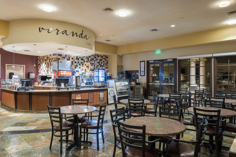 Hotel café interior with counter service, colorful mosaic backsplash, seating area, and welcoming hospitality design