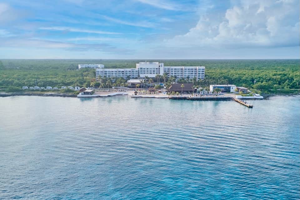 Beachfront all-inclusive resort with white building surrounded by lush tropical jungle