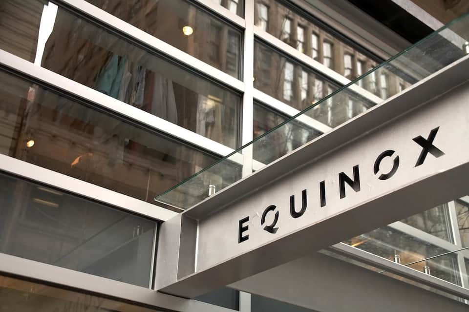 Equinox spa entrance with glass storefront and modern signage in urban setting