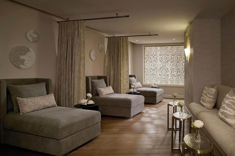 Modern spa relaxation room with lounge chairs, neutral tones, and ambient lighting