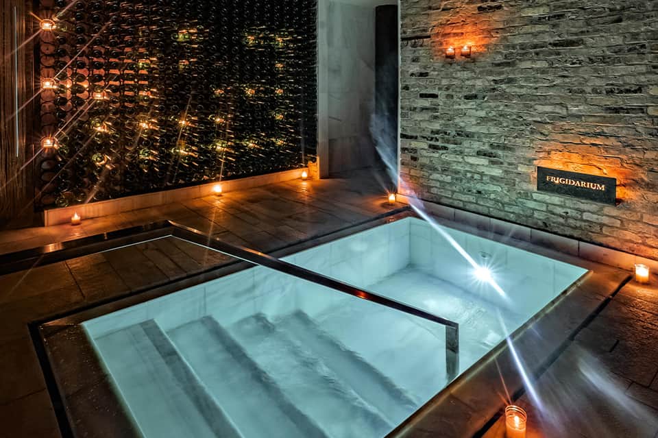 Luxurious spa bath with geometric wall patterns, candlelit ambiance, and stone accents