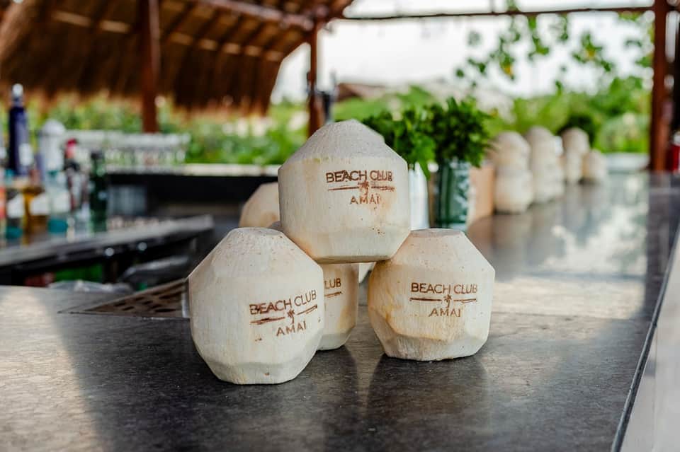 Beach club coconut drinks on counter with tropical garden and wooden pergola in background