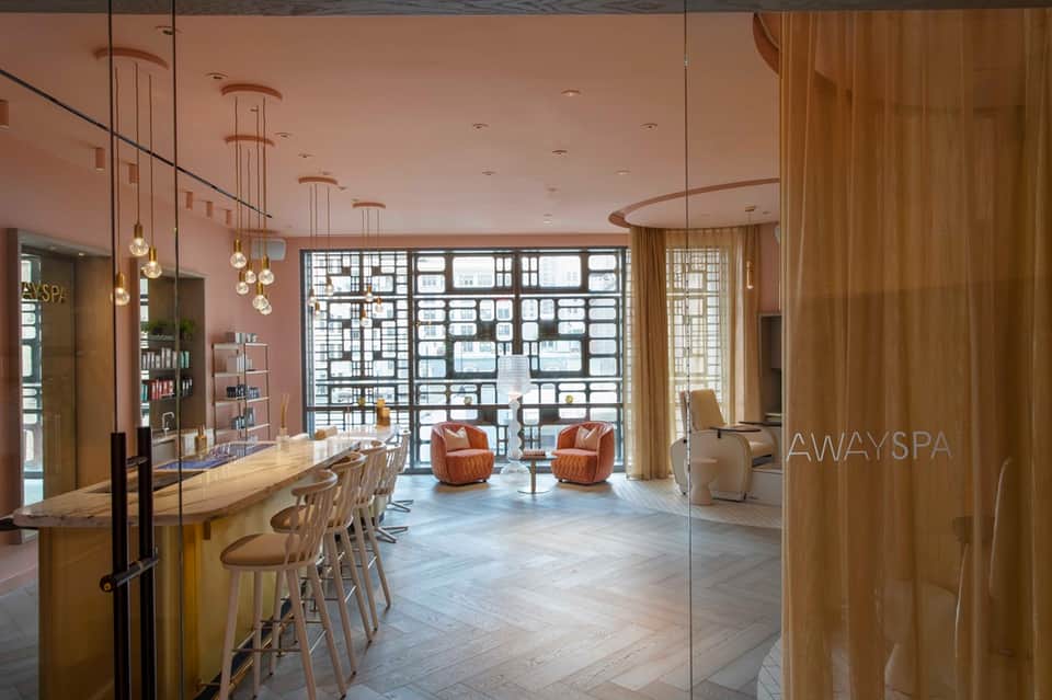 Luxury spa reception area with geometric wall panels, modern furnishings, and elegant design