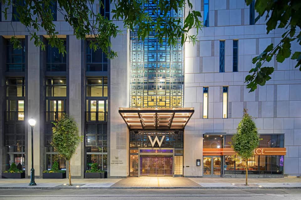 Modern hotel entrance with illuminated W logo and glass facade at night