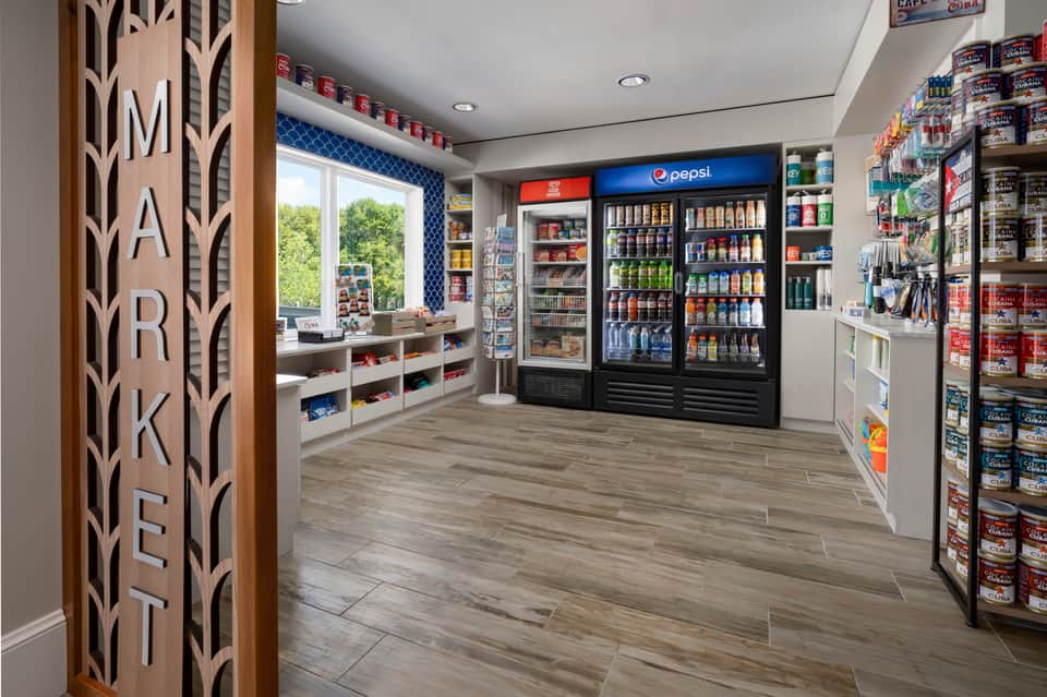 Market interior with refrigerated beverage display, snack shelves, and wood signage