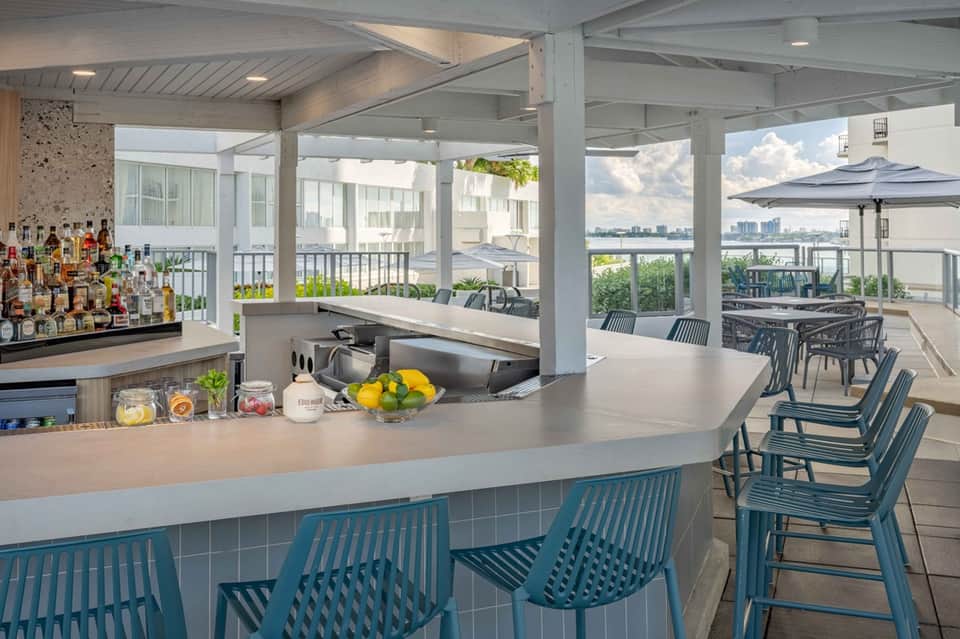 Modern rooftop bar with waterfront views, full bar counter, and outdoor seating