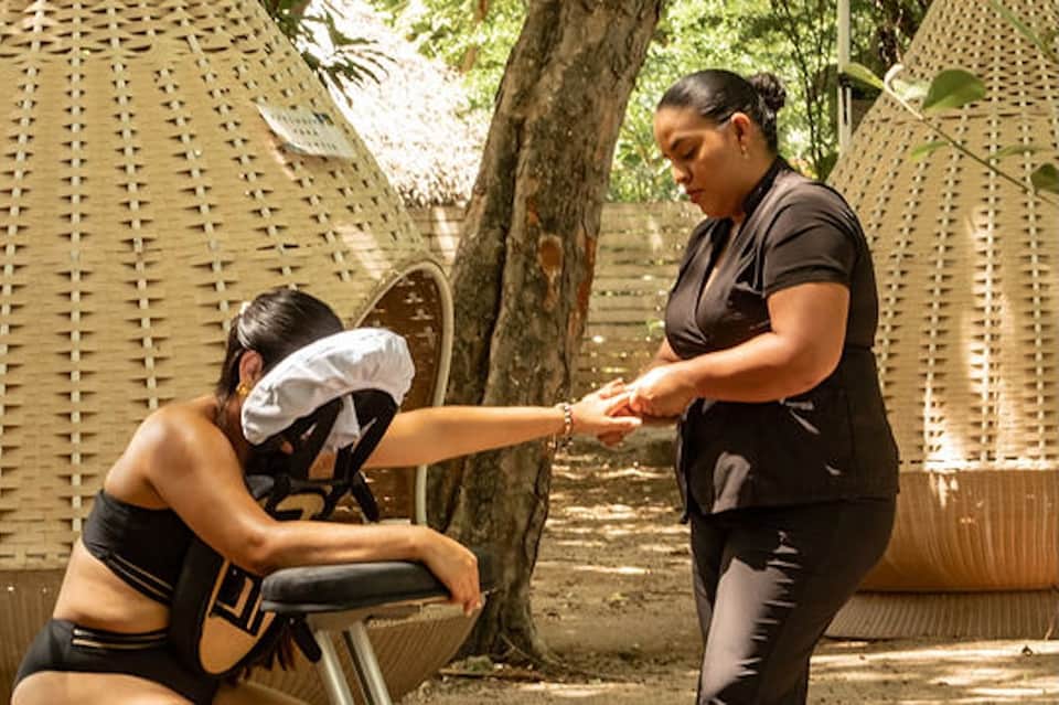 Personal training session outdoors with trainer assisting client in desert spa garden setting