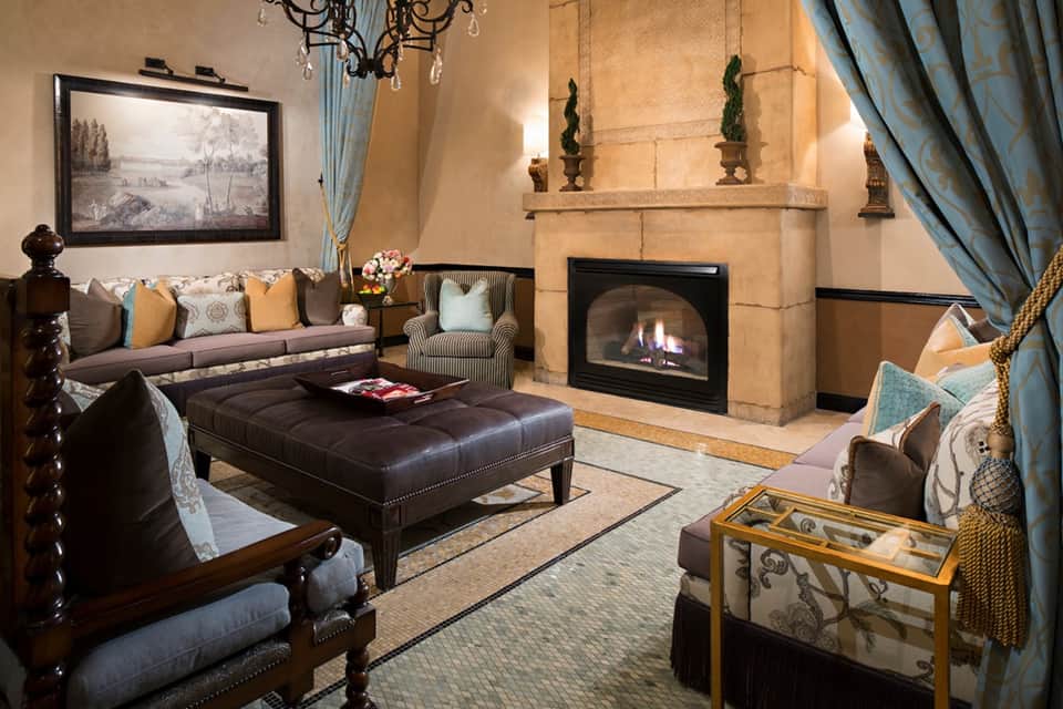 Elegant resort lounge with fireplace, upholstered seating, and classical architectural details