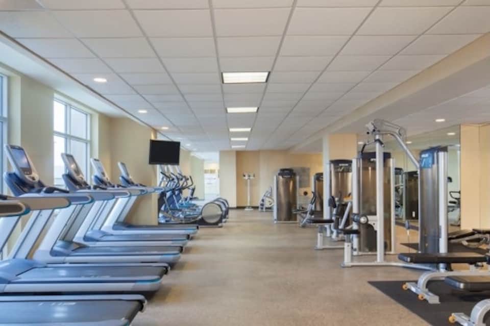 Fitness center with treadmills, exercise equipment, and large windows for natural light
