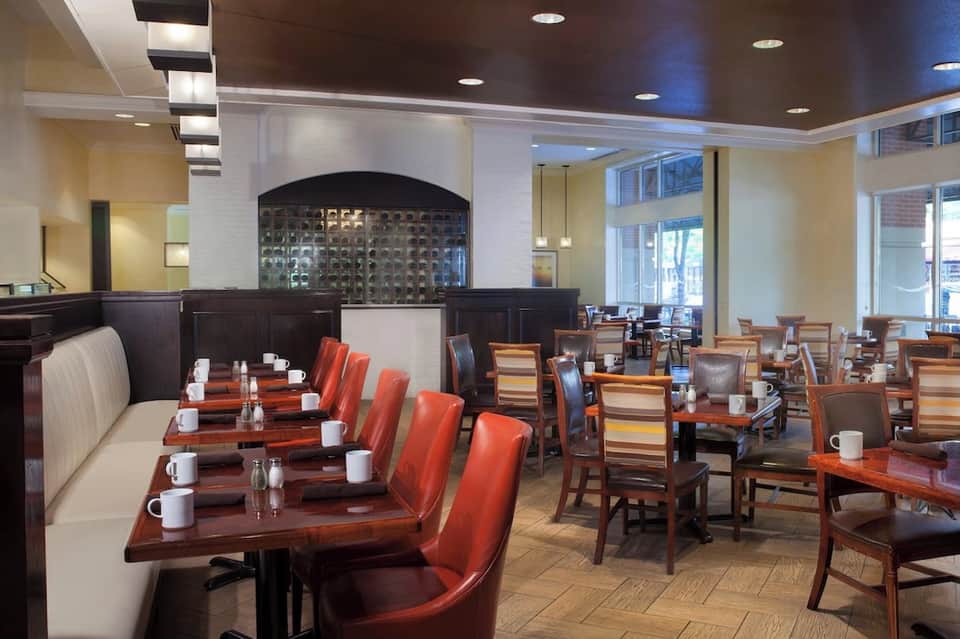 Hotel restaurant dining room with booth seating, wood accents, and modern ceiling design