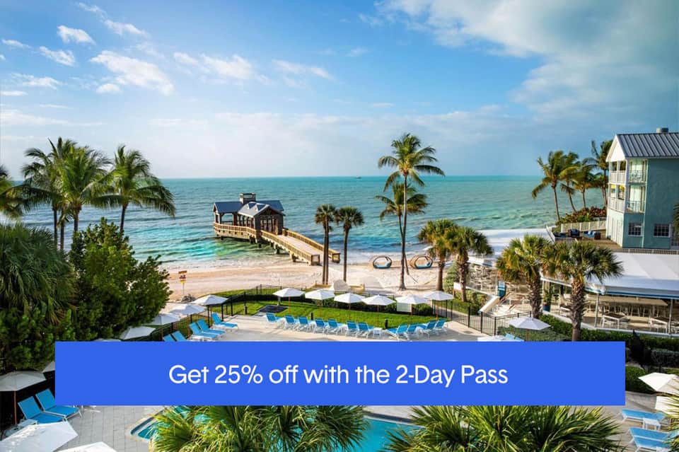 Beachfront resort with pier, pools, palm trees, and turquoise ocean waters