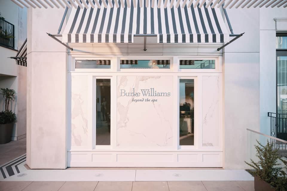 Elegant pink storefront with Burke Williams branding and navy striped awning