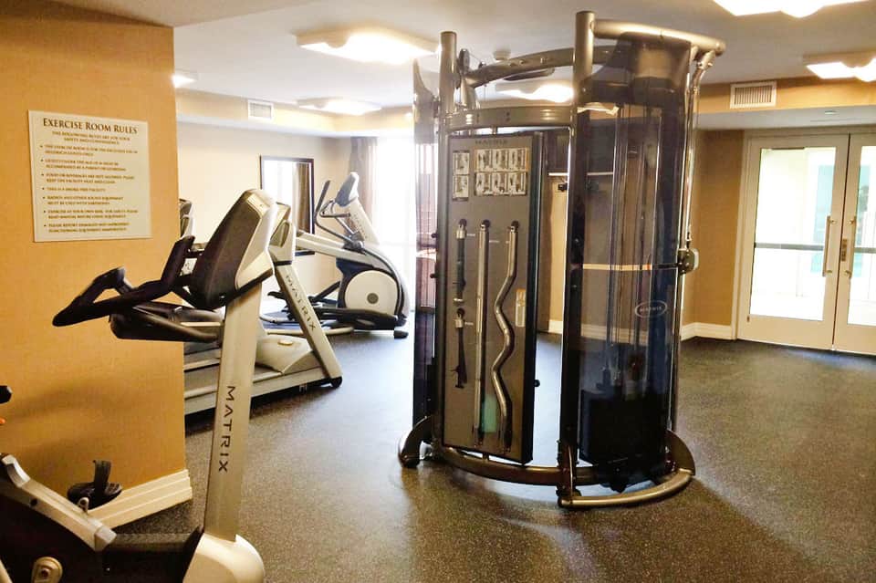Modern fitness center with exercise equipment including elliptical machines and weight training apparatus